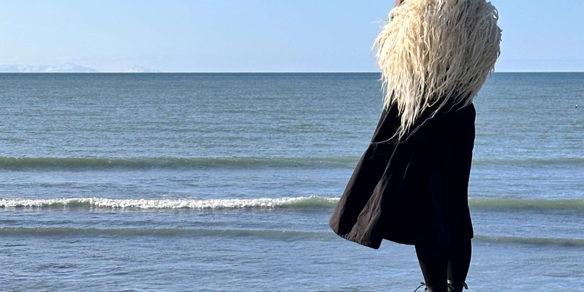 Påkledd i varafell, ser ut over havet