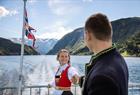 Ungt par ombord i båt på Hardangerfjorden