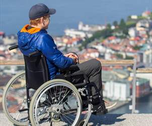 Handikappvennlige attraksjoner og museer i Bergen - gutt i rullestol ser utover Bergen fra Fløyen